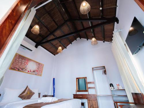 - une chambre avec un lit et un plafond en bois dans l'établissement The Poplar Resort Phú Quốc, à Duong Dong