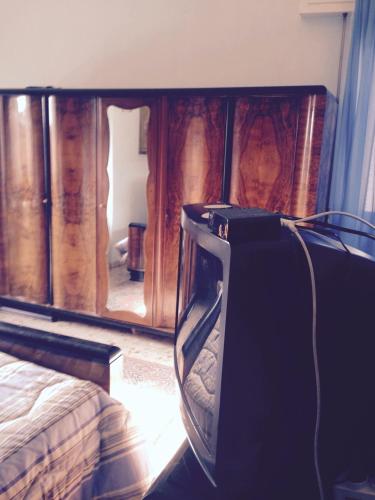 a bedroom with a bed and a wooden cabinet at Stanza Bellaria in Pontedera