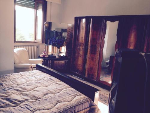 a bedroom with a bed and a chair and a window at Stanza Bellaria in Pontedera