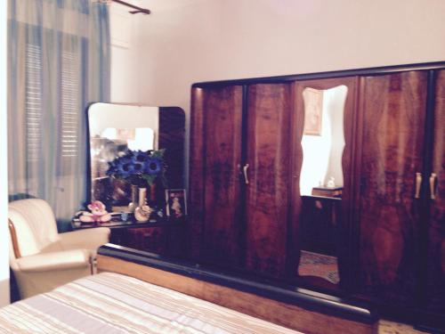 a bedroom with a wooden dresser and a mirror at Stanza Bellaria in Pontedera