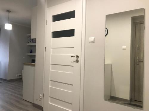 Una puerta blanca en una habitación con cocina en Sweet Home, en Ostróda