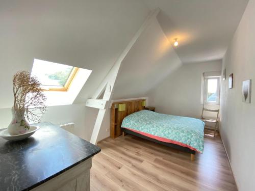 a attic bedroom with a bed and a window at Semi-detached house, Lancheres in Lanchères