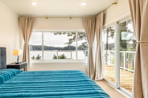 ein Schlafzimmer mit einem Bett und einem großen Fenster in der Unterkunft The Cliffside Poustinia in Kodiak