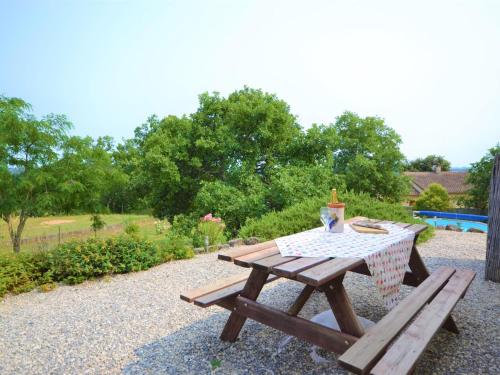 een picknicktafel met een drankje erop bij Alluring Holiday Home in Largenti re with Pool in Largentière