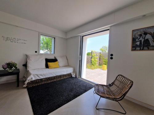 um quarto com uma cama, uma janela e uma cadeira em Holiday Home, La Trinite-sur-Mer em La Trinité-sur-Mer