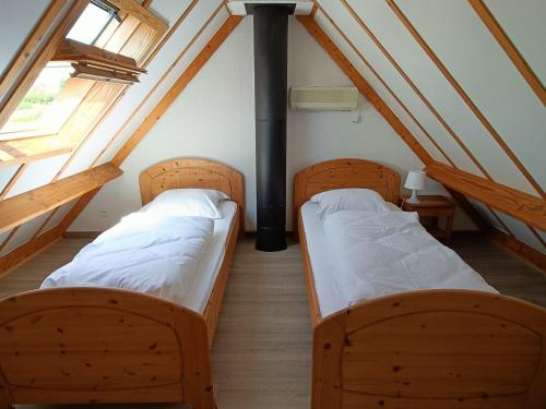 two beds in a room with a roof at Holiday home De Haan in De Haan