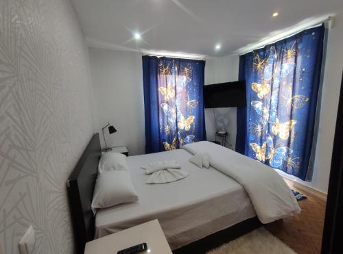um quarto com uma cama grande e cortinas azuis em Memo Moscavide Guest House em Lisboa