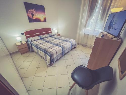 um quarto com uma cama, uma televisão e uma cadeira em La casa di Emma em Terni