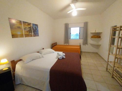 a bedroom with a large white bed and a window at Recanto da Lagoa Flat in Ilha Comprida