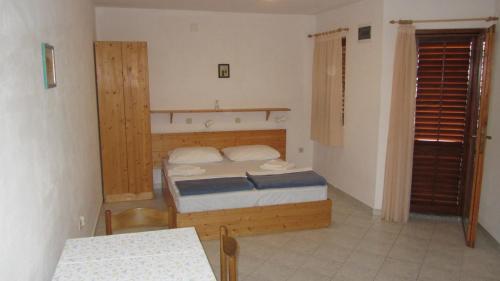 a small bedroom with a bed and a table at Bell Tower apartments in Tisno