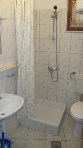 a bathroom with a shower and a toilet and a sink at Bell Tower apartments in Tisno