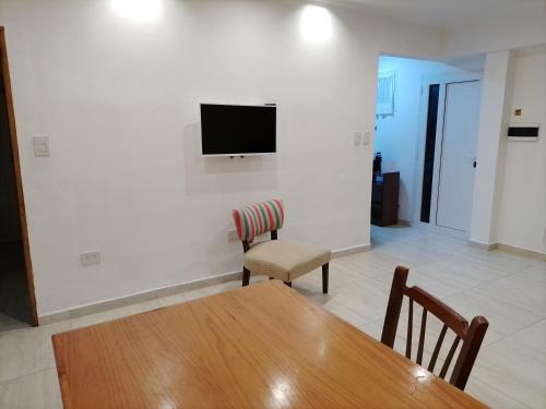 uma sala de estar com uma mesa e uma televisão na parede em RuGra Departamento em Tres Arroyos