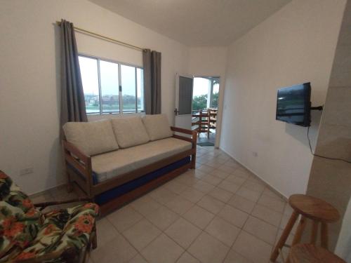 a living room with a couch and a window at Recanto da Lagoa Flat in Ilha Comprida