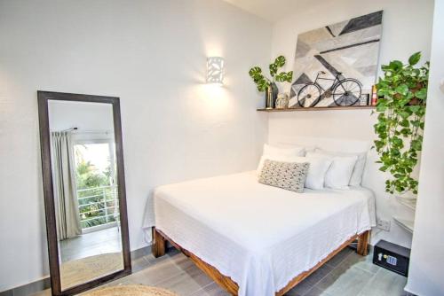a bedroom with a bed and a mirror at Las Vueltas - Golden Zone Studio 2 Blocks to Beach in Bucerías