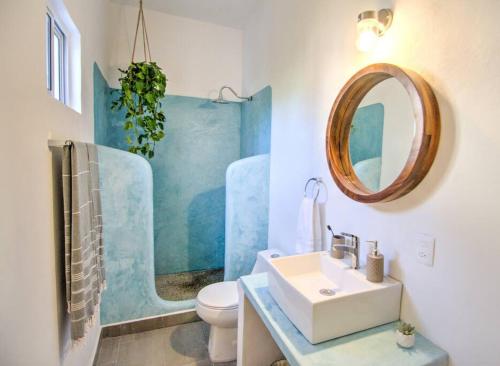 y baño con lavabo, espejo y aseo. en Las Vueltas - Golden Zone Studio 2 Blocks to Beach, en Bucerías