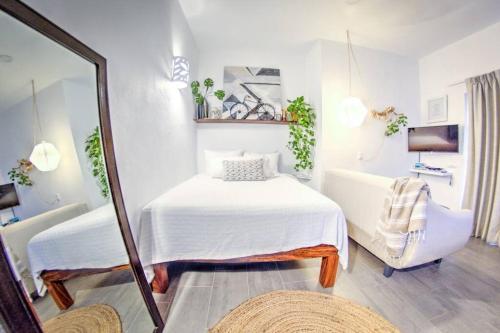 Habitación pequeña con cama y espejo. en Las Vueltas - Golden Zone Studio 2 Blocks to Beach, en Bucerías