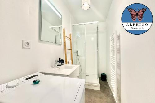 La salle de bains blanche est pourvue d'un lavabo et d'une douche. dans l'établissement Le Platine proche de la gare, à Limoges