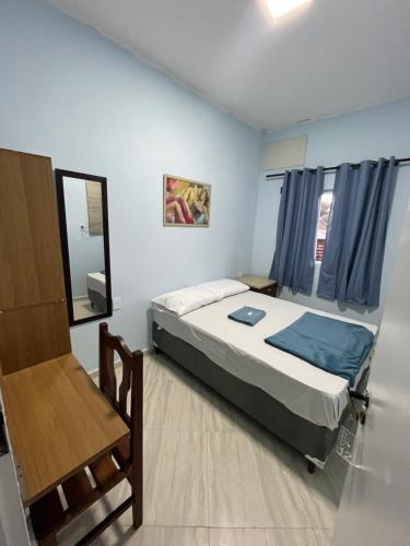 a small bedroom with a bed and a chair at Hotel Cidade Paisagem in Piquete