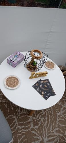 une table blanche avec des livres et d'autres articles dans l'établissement Hé Ma Bulle, à Pleugueneuc