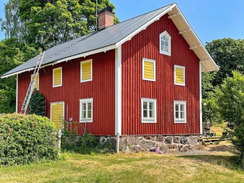 a red barn with yellow shutters on it at 5 person holiday home in VALDEMARSVIK-By Traum in Valdemarsvik