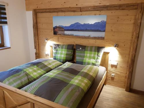 a bedroom with a bed with a wooden wall at Chalet Steinplatte in Reit im Winkl