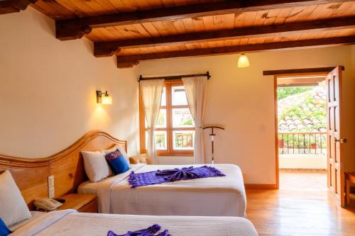 een slaapkamer met 2 bedden en een raam bij HOTEL PROVINCIA in San Cristóbal de Las Casas