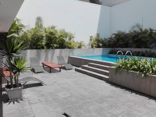 a patio with a pool and a table and chairs at Moderno departamento cerca al malecón in Lima