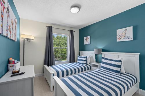 two beds in a room with blue walls at Wish Upon A Splash - Family Villa - 3BR - Private Pool - Disney 4 miles in Kissimmee