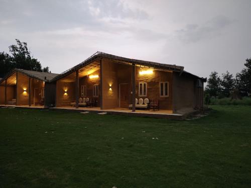a house with a large yard in front of it at Virsaa - The Captain's Mud Retreat in Sirhind