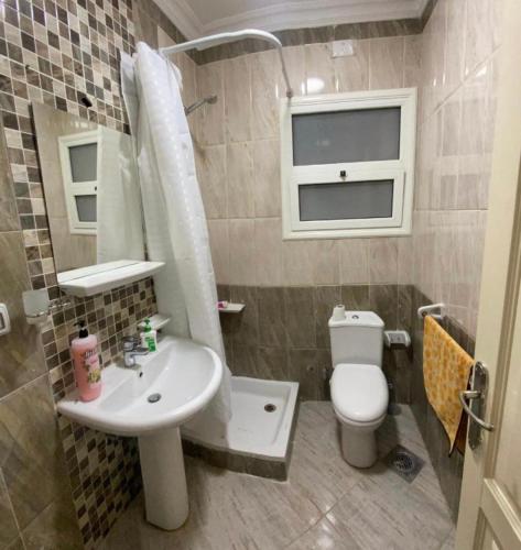 a small bathroom with a sink and a toilet at Madinaty Hotel in Madinaty