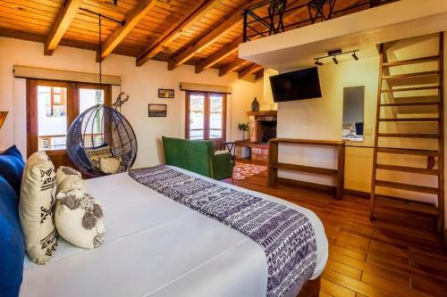 - une chambre avec un grand lit blanc et une échelle dans l'établissement Hotel Kali, à Tapalpa