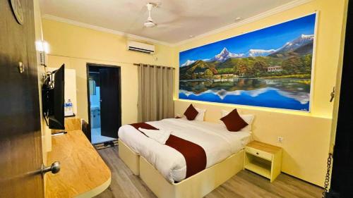 a bedroom with a large painting on the wall at Hotel Peaceland Lumbini in Lumbini