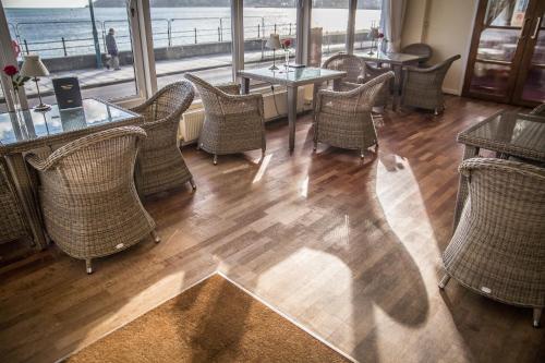 a restaurant with chairs and tables and a view of the ocean at The Queens Hotel in Penzance