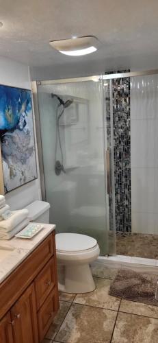 a bathroom with a shower and a toilet and a sink at Kihei Kai Nani Resort in Kihei