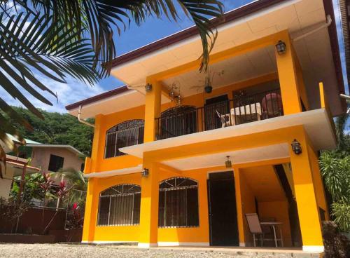 Casa blanca y amarilla con balcón en Mahale - Quepos Manuel Antonio Reserve, en Quepos