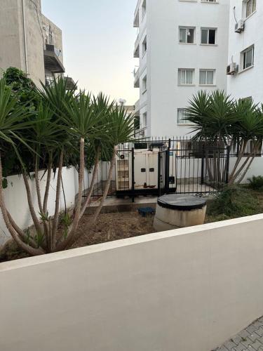 a white fence with palm trees in front of a building at North Residence Havuz Manzaralı Daire in Kérynia