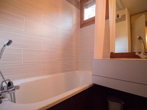 baño con bañera blanca y ventana en Appartement Valmorel, 1 pièce, 4 personnes - FR-1-356-257 en Valmorel