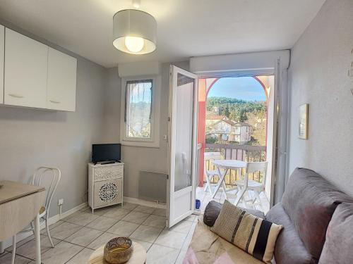 d'un salon avec un canapé et une vue sur un balcon. dans l'établissement Studio avec balcon - Wifi et animaux acceptés - FR-1-451-197, à Lamalou-les-Bains