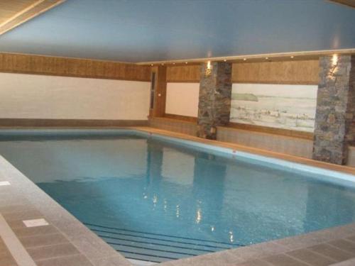 une grande piscine avec de l'eau bleue dans un immeuble dans l'établissement Appartement avec Terrasse, Jardin et Piscine Chauffée à Crest-Voland - 6 Pers. - FR-1-733-136, à Crest-Voland