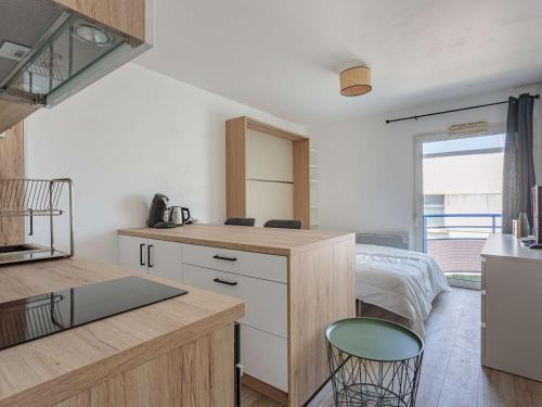 - une cuisine avec un comptoir et un lit dans une chambre dans l'établissement Studio refait à neuf à Anglet, proche commerces & plages, avec balcon et parking gratuit - FR-1-3-594, à Anglet