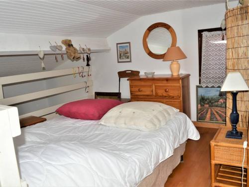une chambre avec un grand lit avec un oreiller rouge dans l'établissement Studio mezzanine avec piscine, parking - 4 pers - Cavalaire - FR-1-226B-166, à Cavalaire-sur-Mer