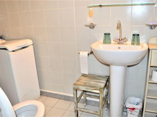La salle de bains est pourvue d'un lavabo et d'un tabouret à côté des toilettes. dans l'établissement Studio mezzanine avec piscine, parking - 4 pers - Cavalaire - FR-1-226B-166, à Cavalaire-sur-Mer