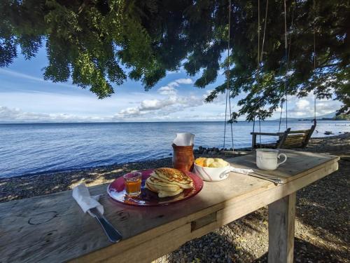 a picnic table with a plate of food on the beach at Hostal La Cascada in Mérida