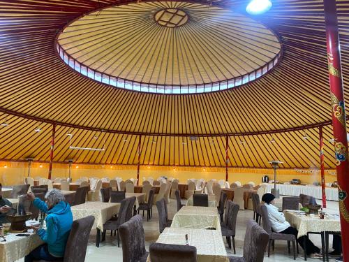 uma sala de jantar com mesas e cadeiras e um tecto em KaoShan Tent Zhangye em Zhangye