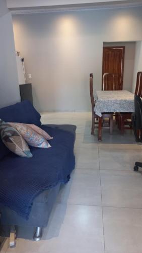 sala de estar con mesa y cama azul en Casa confortável 3 quartos, en Carolina