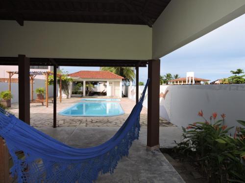 eine Terrasse mit einer Hängematte und einem Pool in der Unterkunft Casabella in Lucena