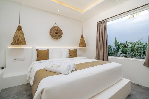 ein weißes Schlafzimmer mit einem großen Bett und einem Fenster in der Unterkunft Villa Ruta I - Sumptuous 2BR Private Luxury Villa Walking Distance to Nyanyi Beach in Tanah Lot