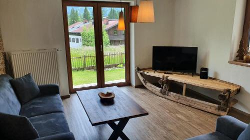 a living room with a couch and a tv and a table at Chalet Weitsee in Reit im Winkl