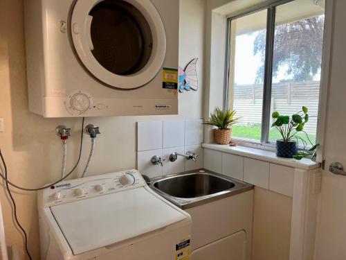 a small kitchen with a sink and a microwave at Wrentree - Pet Friendly Inside 26B Laurel Tce in Robe