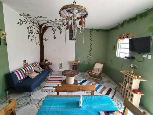 een woonkamer met een boom op de muur bij Qué Chula casa. in Izamal